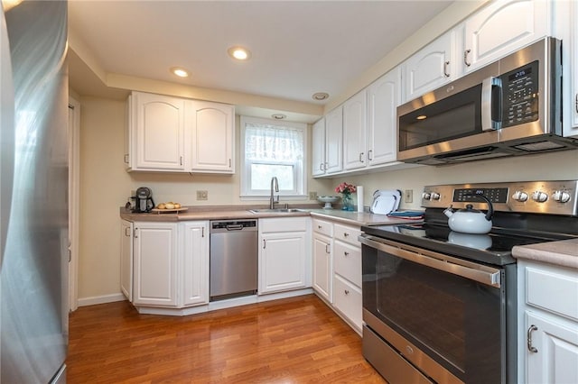 4800 W Brierly Dr, West Mifflin, PA 15122 - kitchen featuring appliances with stainless steel finishes, light wood finished floors, recessed lighting, white cabinetry, and light countertops
