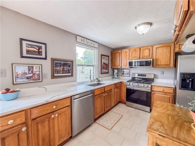 534 Hunters Path Rd, South Fayette, PA 15017 - kitchen featuring appliances with stainless steel finishes, light stone countertops, brown cabinetry, and a textured ceiling