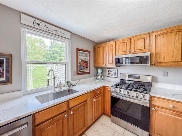 534 Hunters Path Rd, South Fayette, PA 15017 - kitchen with appliances with stainless steel finishes, a textured ceiling, light tile patterned flooring, light stone countertops, and brown cabinetry