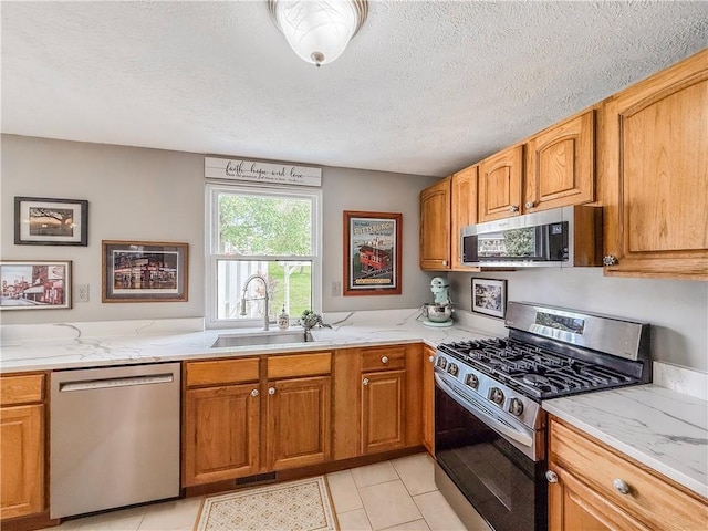 534 Hunters Path Rd, South Fayette, PA 15017 - kitchen with appliances with stainless steel finishes, light stone counters, light tile patterned floors, a textured ceiling, and brown cabinets