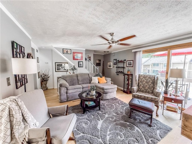 534 Hunters Path Rd, South Fayette, PA 15017 - living room with stairs, light wood-style floors, a textured ceiling, ceiling fan, and ornamental molding