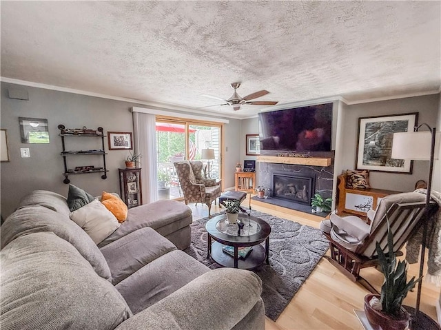 534 Hunters Path Rd, South Fayette, PA 15017 - living room with wood finished floors, ornamental molding, a ceiling fan, a fireplace with raised hearth, and a textured ceiling