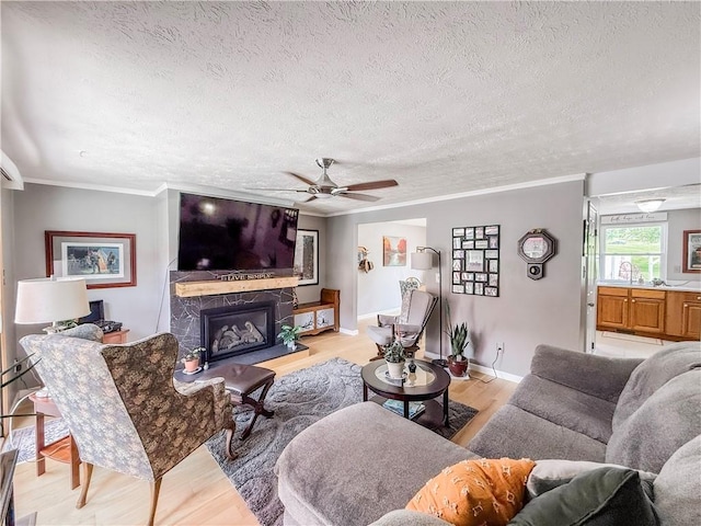 534 Hunters Path Rd, South Fayette, PA 15017 - living area with a textured ceiling, light wood-style flooring, a premium fireplace, crown molding, and ceiling fan