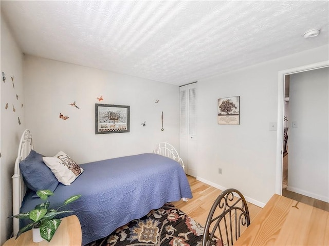 534 Hunters Path Rd, South Fayette, PA 15017 - bedroom with light wood-style floors, a textured ceiling, and a closet