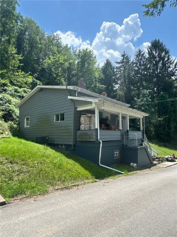 6036 Sawyer St, Lawrenceville, PA 15201 - view of side of home with a chimney, a porch, a lawn, and stairway
