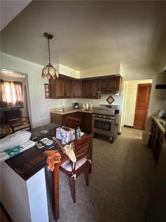 6036 Sawyer St, Lawrenceville, PA 15201 - kitchen with stainless steel range, under cabinet range hood, dark brown cabinetry, decorative light fixtures, and dark carpet
