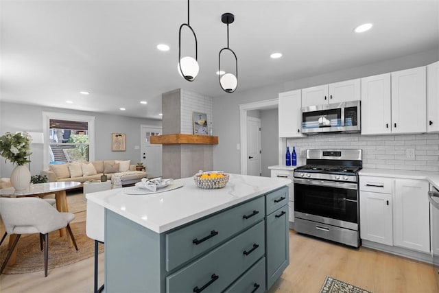 1610 Duffield St, Morningside, PA 15206 - kitchen featuring appliances with stainless steel finishes, white cabinetry, light countertops, a kitchen island, and light wood-style floors