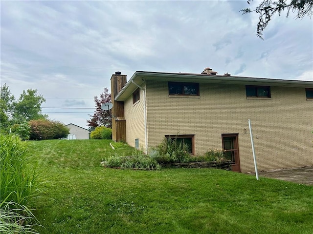 130 Overlook Dr, Brighton Twp, PA 15009 - view of home's exterior with a chimney, brick siding, and a lawn