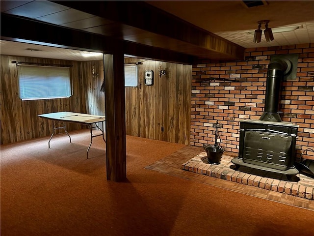 130 Overlook Dr, Brighton Twp, PA 15009 - below grade area with a wood stove, wooden walls, and carpet floors
