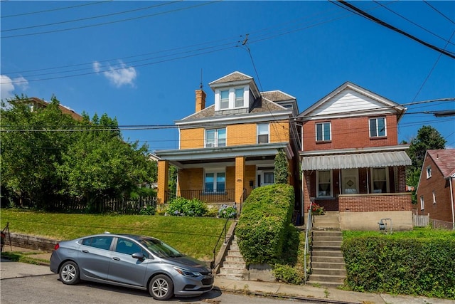 2102 Vodeli St, Beechview, PA 15216 - view of front facade featuring brick siding, a porch, stairway, a front lawn, and a chimney