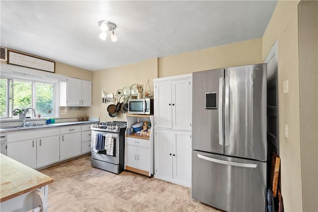 2102 Vodeli St, Beechview, PA 15216 - kitchen featuring stainless steel appliances, white cabinets, and light countertops