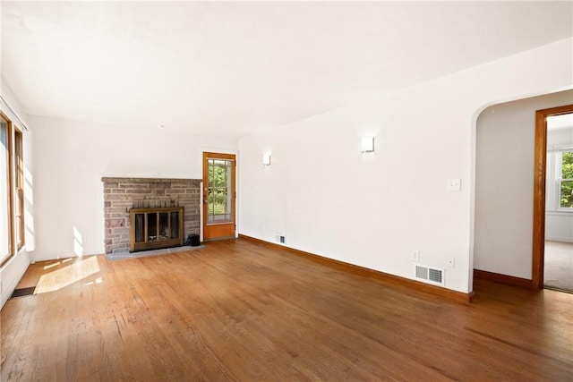 1837 Stoystown, Somerset Twp, PA 15541 - unfurnished living room with wood finished floors, healthy amount of natural light, a glass covered fireplace, and arched walkways