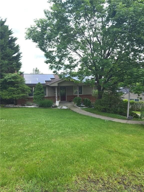 5215 Caste Dr, Whitehall, PA 15236 - view of front of home with solar panels, a front yard, and a metal roof