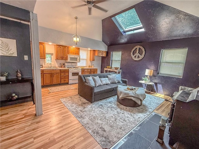 808 Thompson Run Rd, Springdale Twp, PA 15049 - living area featuring a skylight, ceiling fan, light wood-type flooring, and high vaulted ceiling