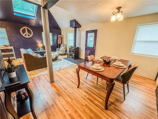808 Thompson Run Rd, Springdale Twp, PA 15049 - dining area featuring a wood stove, light wood-style floors, lofted ceiling, and a skylight