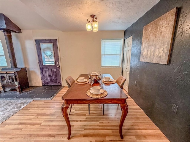 808 Thompson Run Rd, Springdale Twp, PA 15049 - dining area with wood finished floors, a wood stove, and a textured ceiling