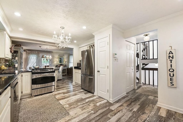 1115 Valleyview Dr, Cecil, PA 15055 - kitchen featuring appliances with stainless steel finishes, a chandelier, wood finished floors, dark countertops, and crown molding