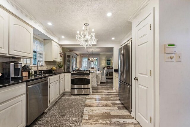 1115 Valleyview Dr, Cecil, PA 15055 - kitchen featuring stainless steel appliances, a chandelier, ornamental molding, light wood-type flooring, and healthy amount of natural light