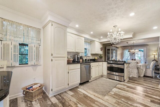 1115 Valleyview Dr, Cecil, PA 15055 - kitchen featuring a chandelier, stainless steel appliances, crown molding, dark countertops, and light wood-style flooring