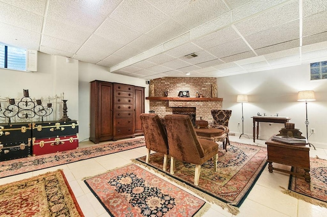 1115 Valleyview Dr, Cecil, PA 15055 - living room featuring a brick fireplace, light tile patterned floors, and a paneled ceiling