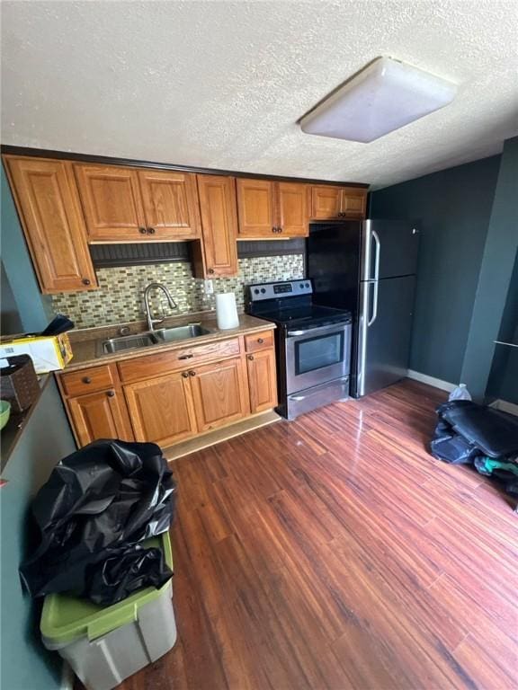 5015 Walnut St, Versailles Boro, PA 15132 - kitchen with stainless steel electric range oven, freestanding refrigerator, dark wood finished floors, a textured ceiling, and brown cabinetry