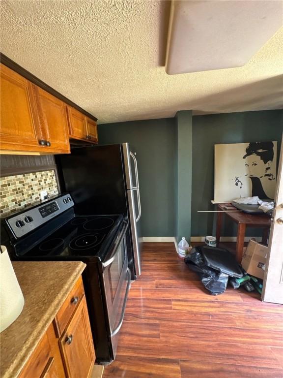 5015 Walnut St, Versailles Boro, PA 15132 - kitchen featuring electric stove, brown cabinetry, dark wood-type flooring, backsplash, and a textured ceiling