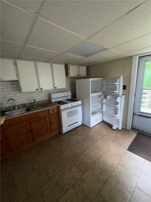 5015 Walnut St, Versailles Boro, PA 15132 - kitchen with white appliances, a drop ceiling, backsplash, white cabinets, and light countertops
