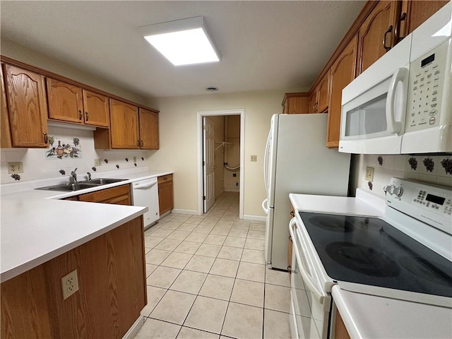 1009 Ironwood Cir, Jeannette, PA 15644 - kitchen with white appliances, brown cabinetry, light countertops, and light tile patterned flooring