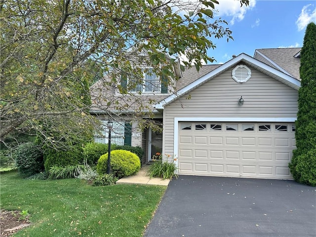 1009 Ironwood Cir, Jeannette, PA 15644 - view of front of house with asphalt driveway, a shingled roof, a front lawn, and an attached garage
