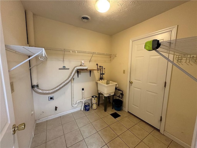 1009 Ironwood Cir, Jeannette, PA 15644 - laundry area with hookup for an electric dryer, light tile patterned floors, and a textured ceiling