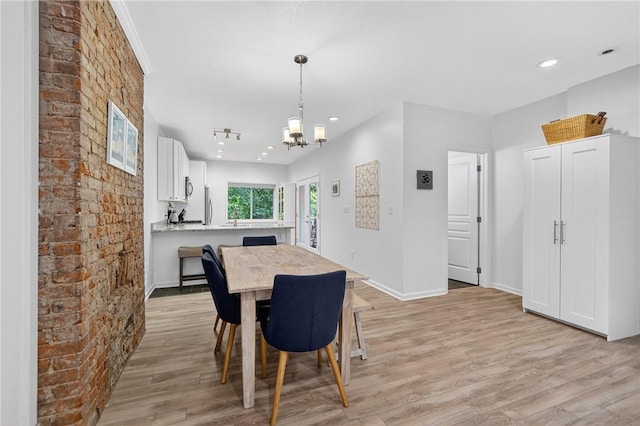 4536 Friendship Ave, Bloomfield, PA 15224 - dining room featuring a chandelier, light wood finished floors, brick wall, and recessed lighting