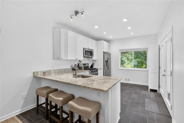 4536 Friendship Ave, Bloomfield, PA 15224 - kitchen featuring stainless steel appliances, a breakfast bar, recessed lighting, light stone countertops, and a peninsula