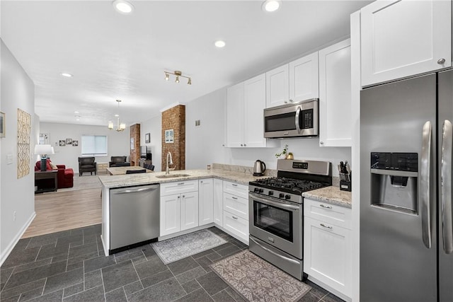 4536 Friendship Ave, Bloomfield, PA 15224 - kitchen featuring appliances with stainless steel finishes, a peninsula, white cabinetry, open floor plan, and recessed lighting