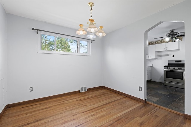 242 Millport Rd, West Mifflin, PA 15122 - unfurnished dining area featuring arched walkways, wood finished floors, ceiling fan, and a chandelier