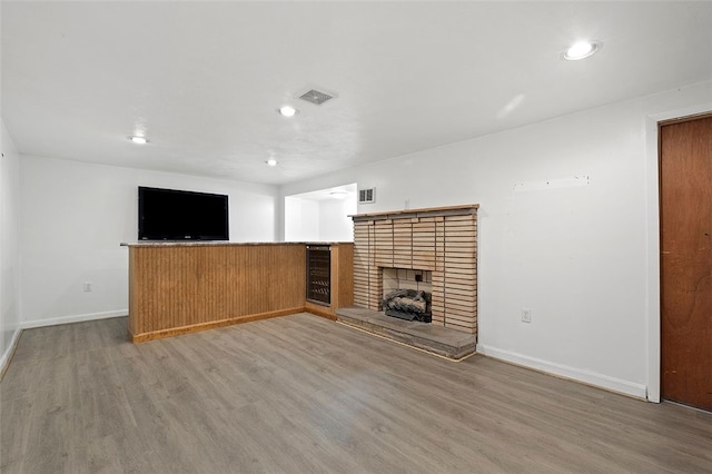 242 Millport Rd, West Mifflin, PA 15122 - unfurnished living room with wood finished floors, a brick fireplace, and recessed lighting