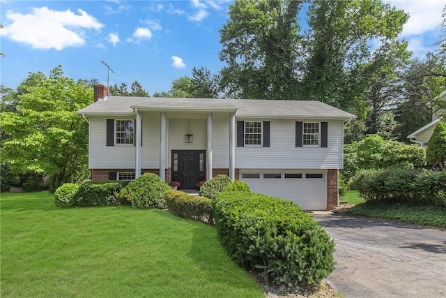 231 W Shaffer Rd, Center Twp, PA 15001 - split foyer home with asphalt driveway, an attached garage, a chimney, and a front yard