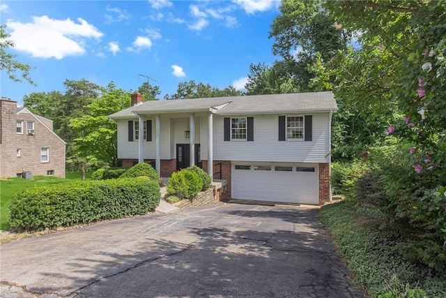 231 W Shaffer Rd, Center Twp, PA 15001 - raised ranch with asphalt driveway, brick siding, an attached garage, and a chimney