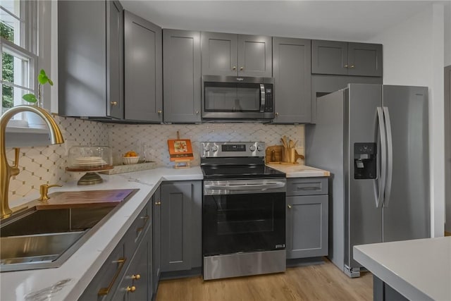 231 W Shaffer Rd, Center Twp, PA 15001 - kitchen with appliances with stainless steel finishes, light wood-type flooring, gray cabinets, and decorative backsplash
