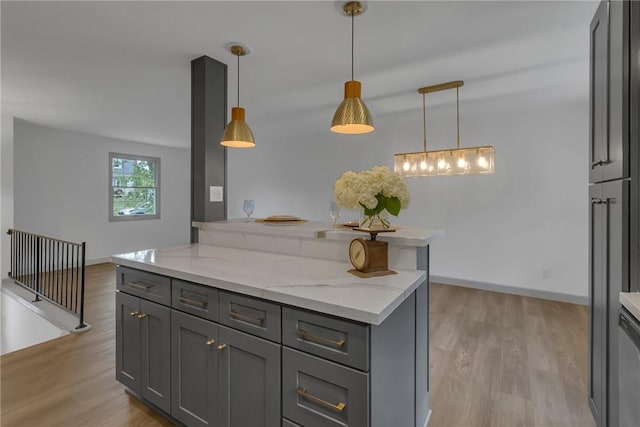 231 W Shaffer Rd, Center Twp, PA 15001 - kitchen with gray cabinetry, light wood finished floors, and light stone countertops