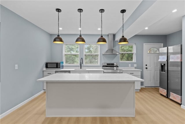 3322 Webster Ave, Schenley Heights, PA 15219 - kitchen with wall chimney range hood, appliances with stainless steel finishes, light countertops, light wood-type flooring, and white cabinets