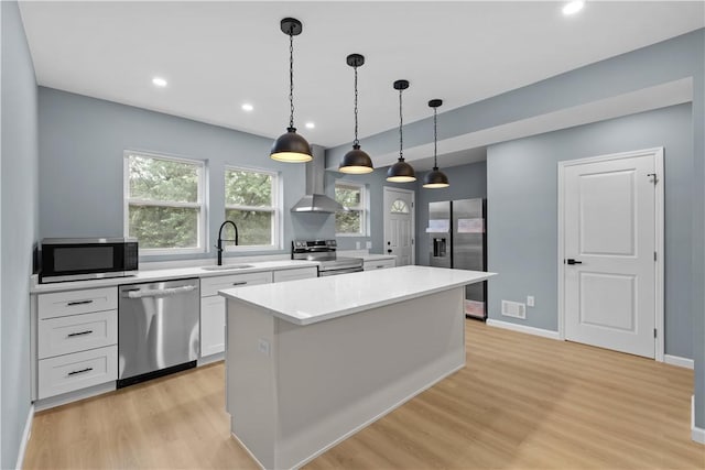 3322 Webster Ave, Schenley Heights, PA 15219 - kitchen with appliances with stainless steel finishes, wall chimney range hood, light wood-type flooring, white cabinetry, and light countertops