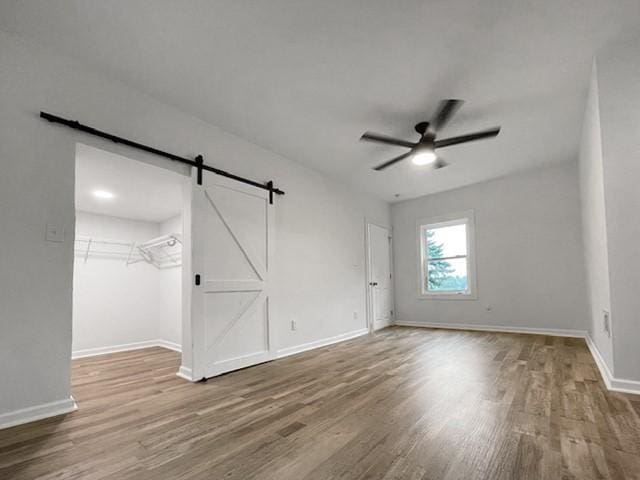1713 Belasco Ave, Beechview, PA 15216 - unfurnished bedroom featuring wood finished floors, a barn door, ceiling fan, and a spacious closet