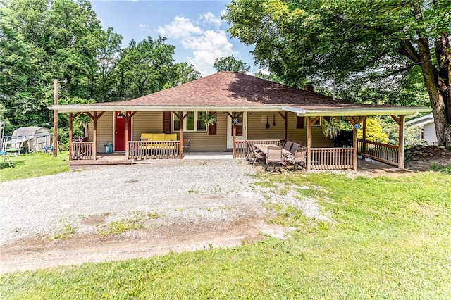 132 Spaugy Hollow Rd, Bullskin Twp, PA 15425 - back of house featuring covered porch, a lawn, driveway, roof with shingles, and a storage shed
