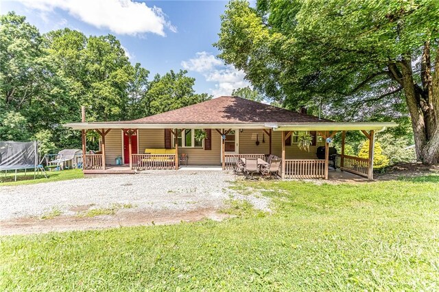 132 Spaugy Hollow Rd, Bullskin Twp, PA 15425 - view of front of house featuring covered porch, a trampoline, and a front lawn