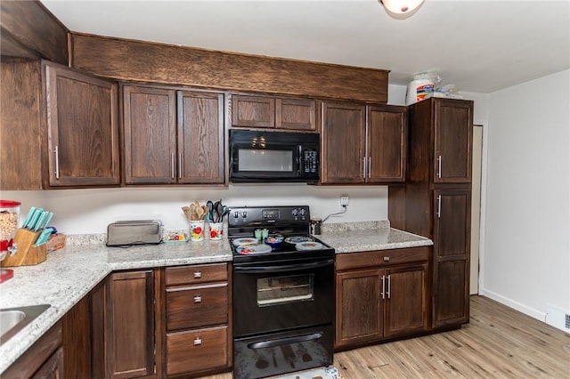 132 Spaugy Hollow Rd, Bullskin Twp, PA 15425 - kitchen with black appliances, light wood-style floors, dark brown cabinetry, and light stone counters