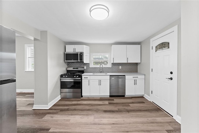 613-615 W Main St, Carnegie, PA 15106 - kitchen featuring appliances with stainless steel finishes, light countertops, white cabinetry, and backsplash