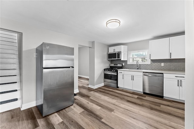 613-615 W Main St, Carnegie, PA 15106 - kitchen featuring stainless steel appliances, light countertops, white cabinetry, tasteful backsplash, and wood finished floors