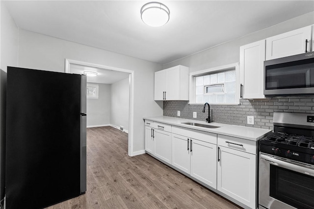 613-615 W Main St, Carnegie, PA 15106 - kitchen featuring appliances with stainless steel finishes, light countertops, backsplash, and white cabinetry