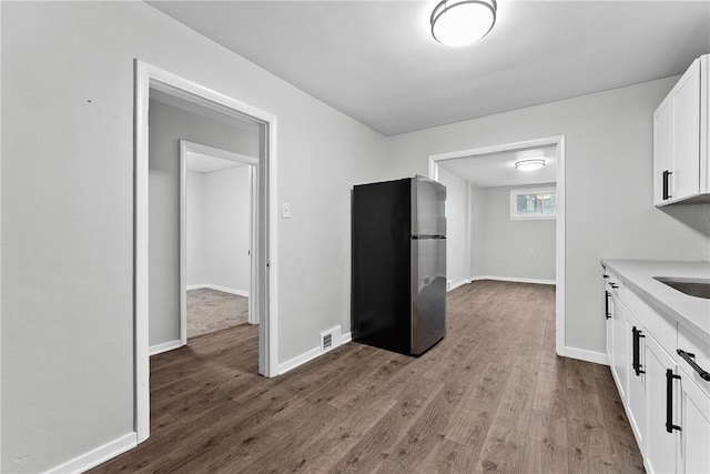 613-615 W Main St, Carnegie, PA 15106 - kitchen featuring freestanding refrigerator, white cabinets, light wood-type flooring, and light countertops
