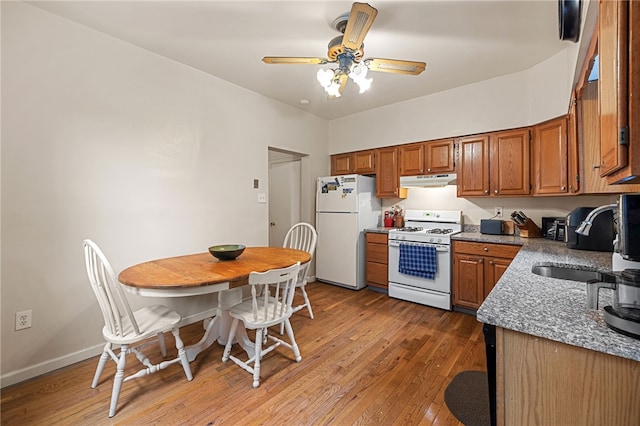 316 Kaercher St, Greenfield, PA 15207 - kitchen featuring white appliances, under cabinet range hood, light wood-style flooring, and brown cabinetry
